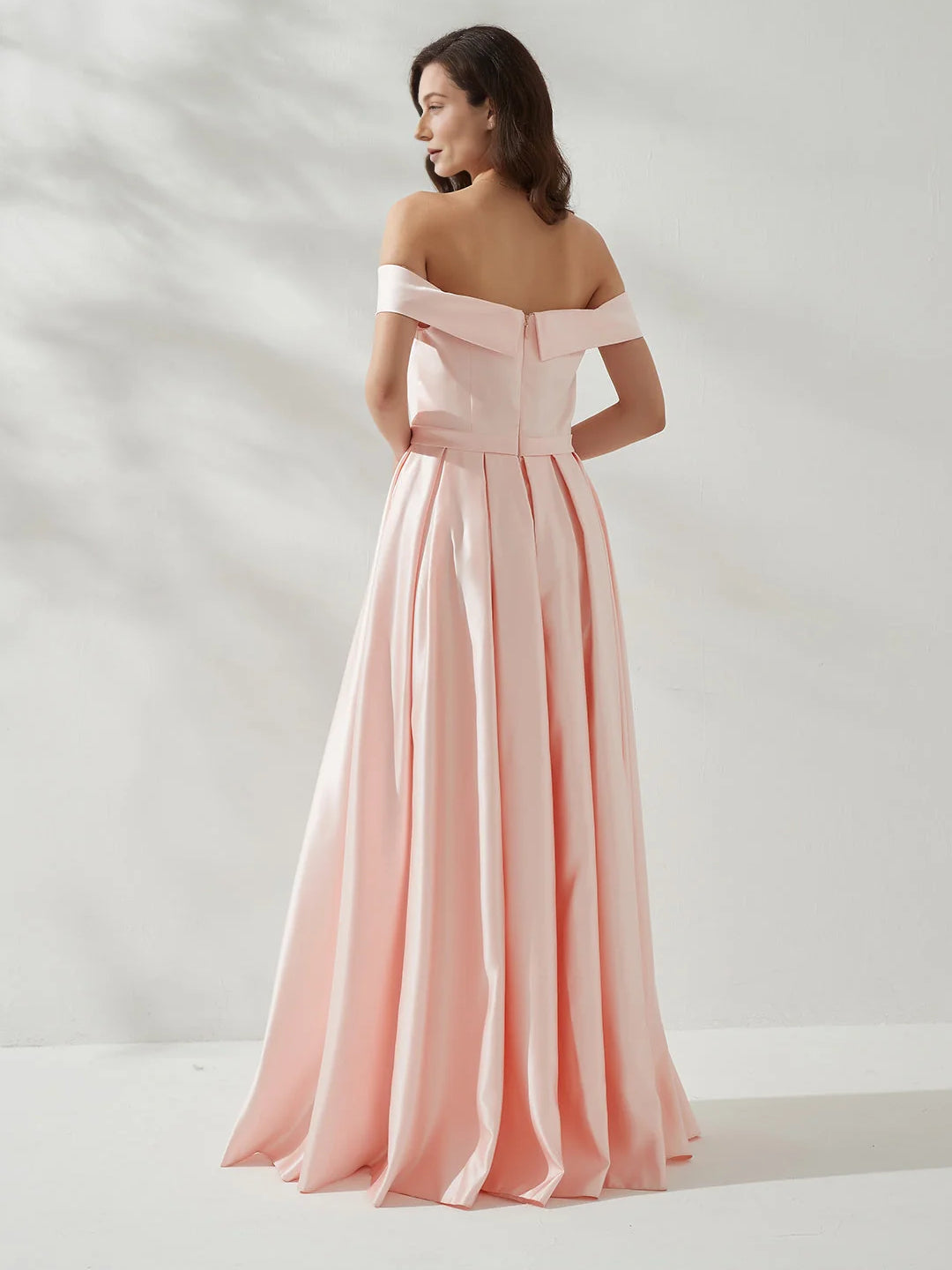 Peach off-shoulder formal dress with open back, draped skirt and thigh slit, floor-length