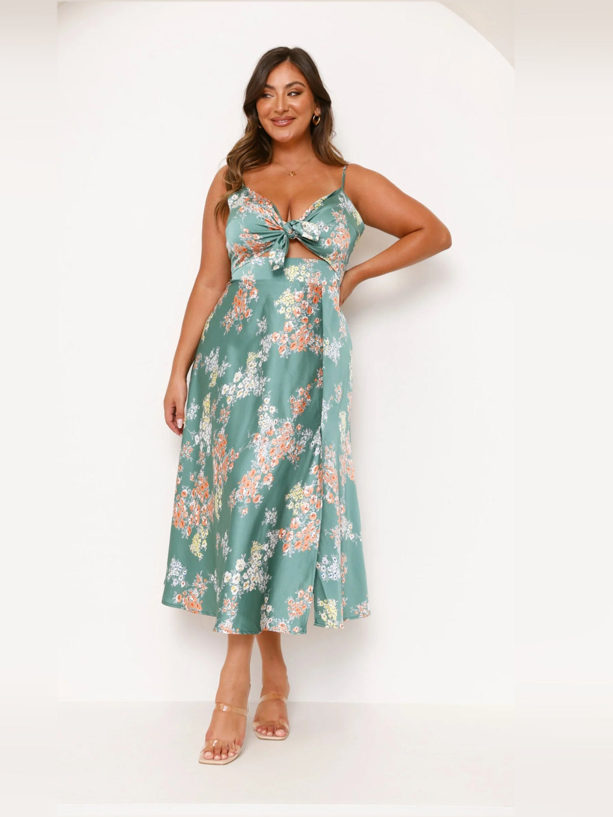 Green floral midi dress with bow-tie bodice, spaghetti straps, and flared skirt