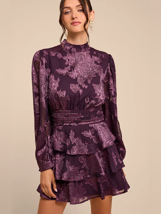 Purple floral tiered mini dress with high neckline and long sleeves, fitted waist