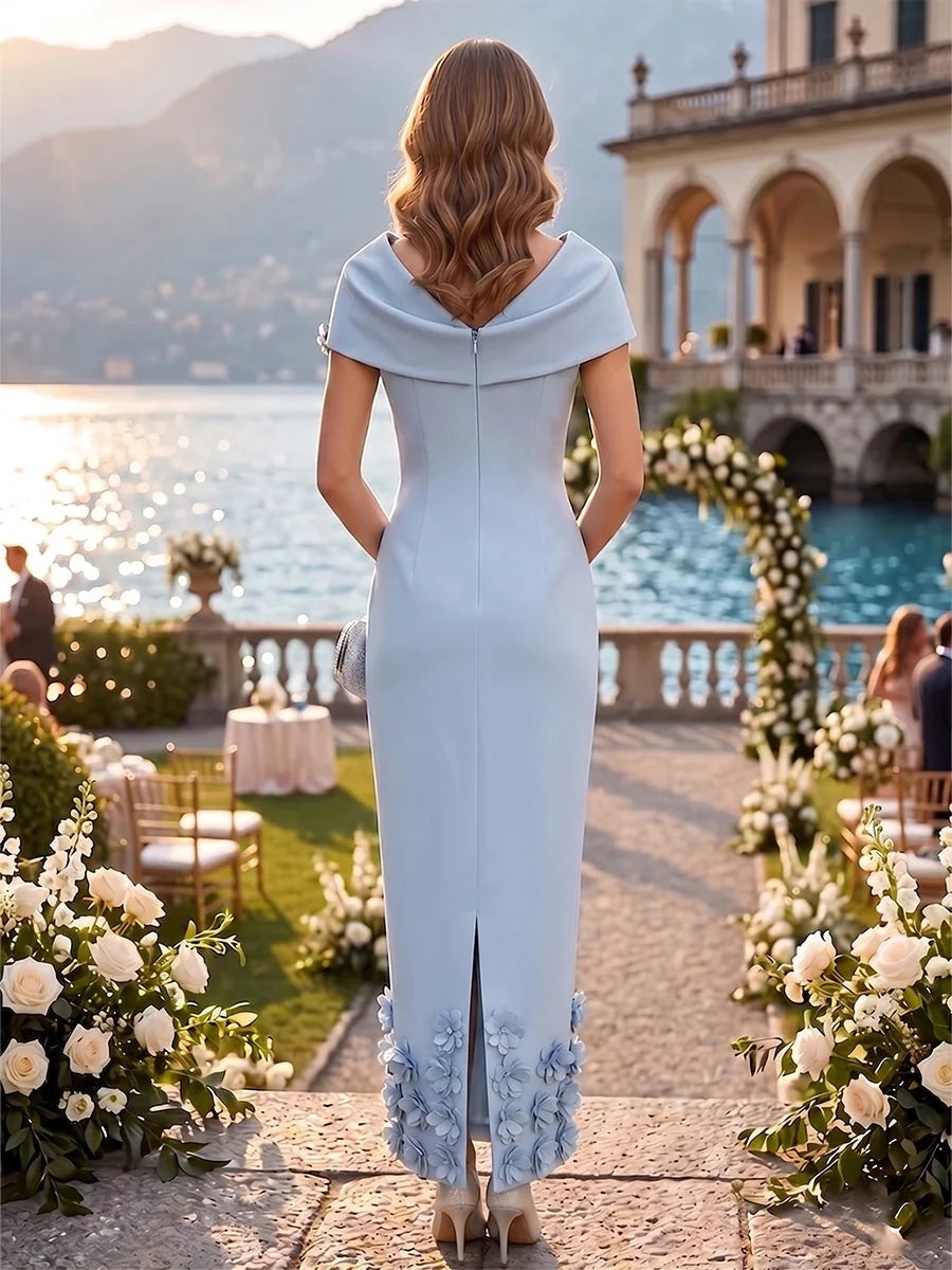 Light blue midi sheath dress with back drape and floral applique detail at hem.