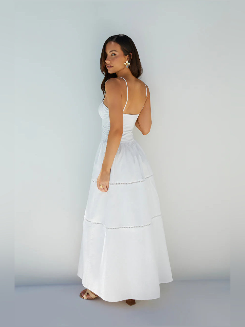 White a-line maxi formal dress with tiered skirt, full-length back view
