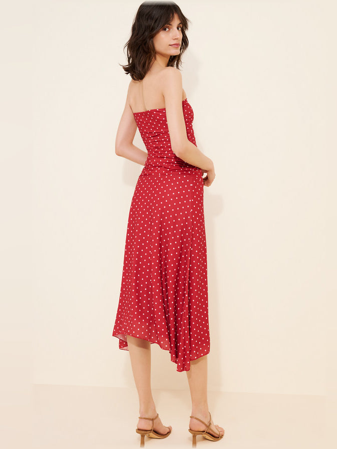 Red polka-dot strapless midi dress, side view, with fitted bodice and flared hem