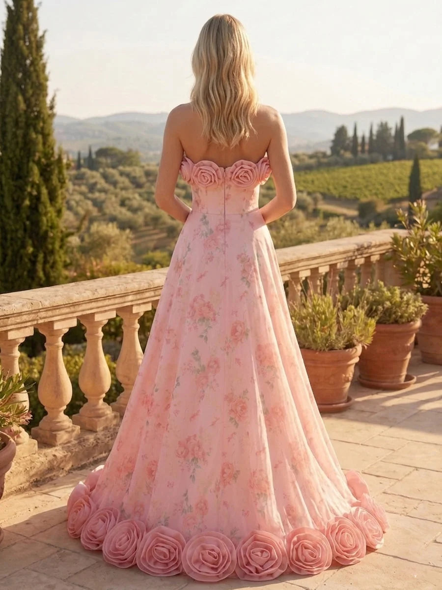 Back view of pink strapless A-line floor-length dress with floral print and rose hem rosettes