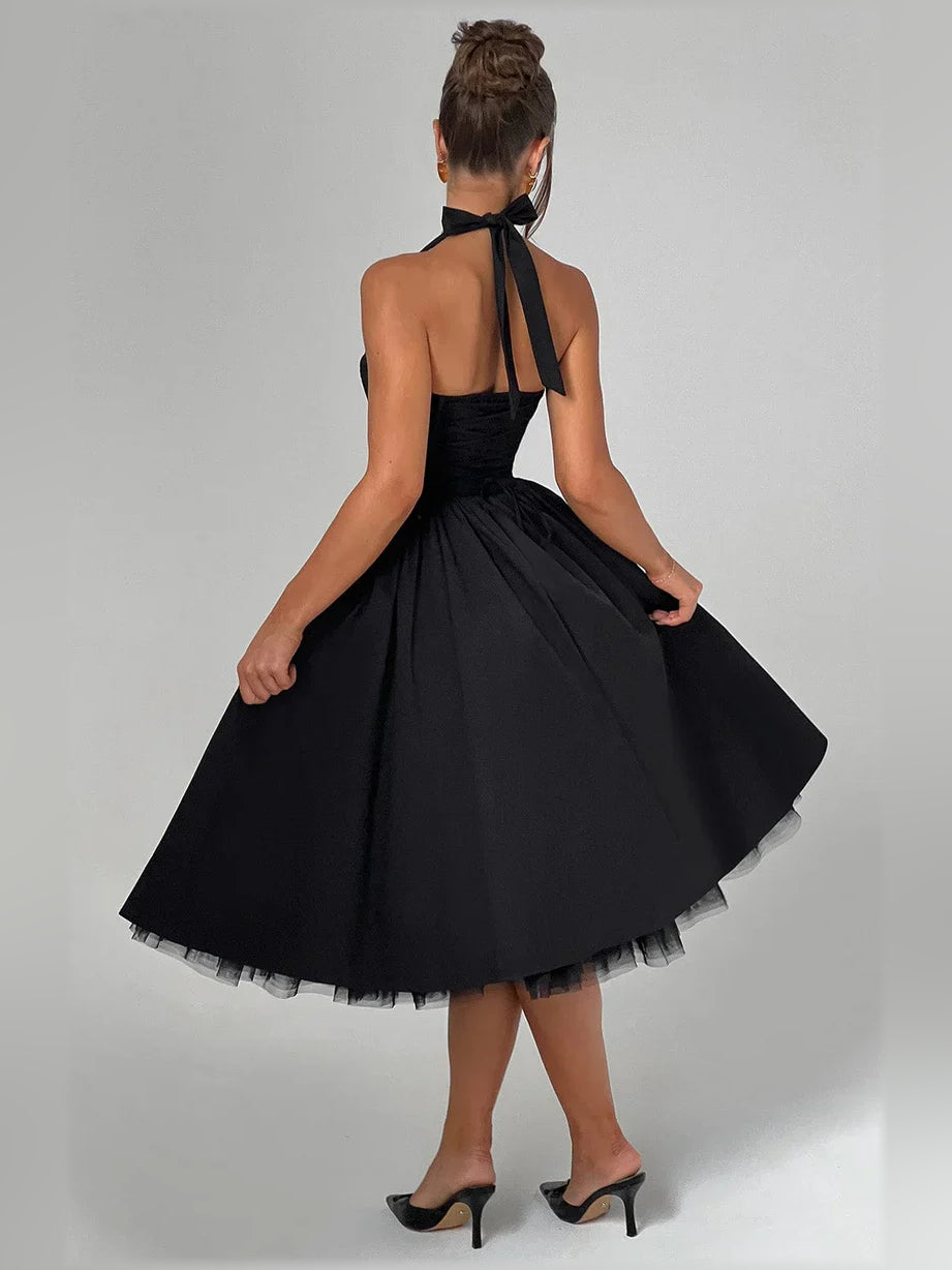 Back view of black halter A-line midi formal dress with crisscross halter straps