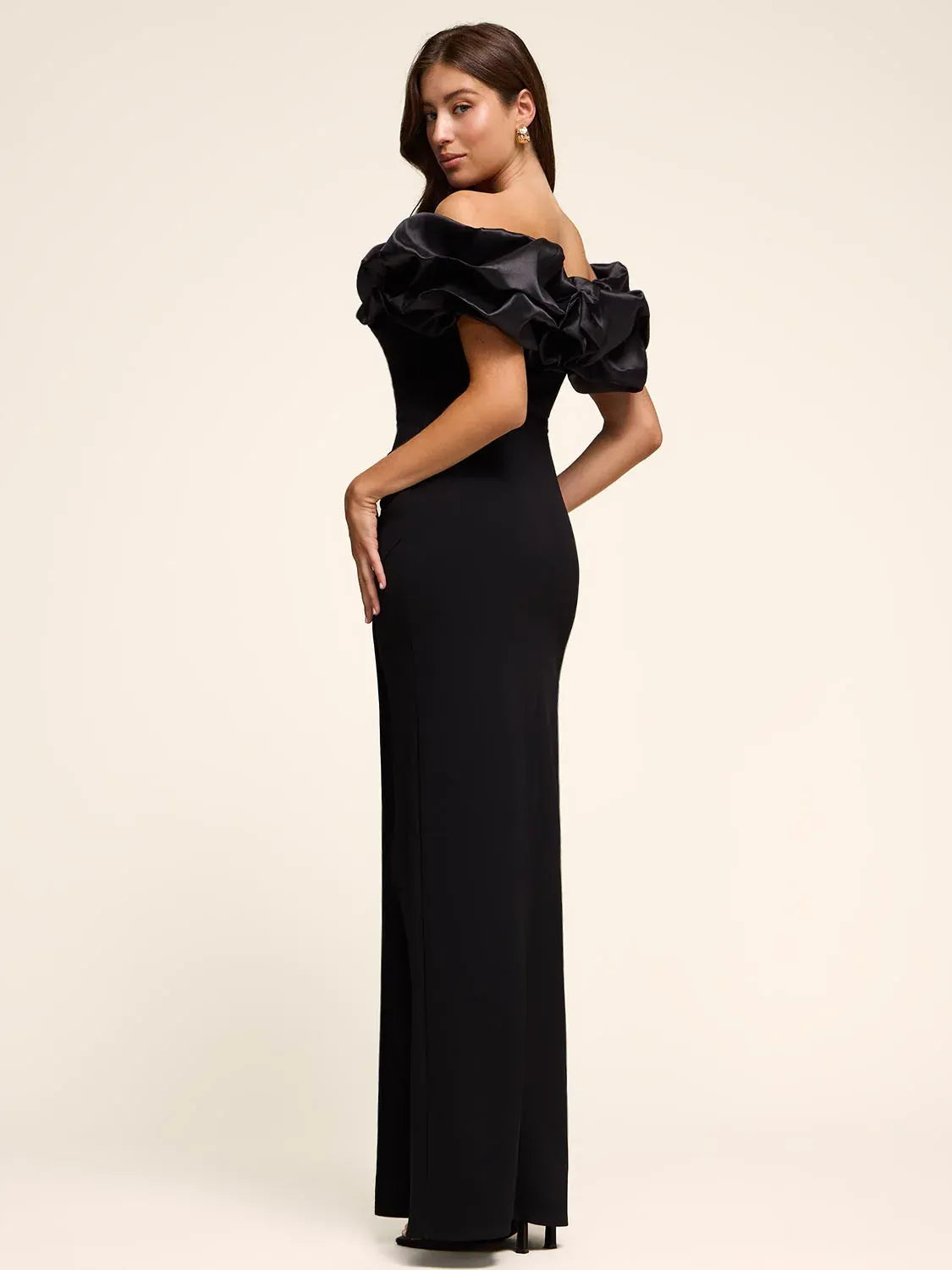 Black off-shoulder ruffle floor-length formal dress, side view with thigh slit
