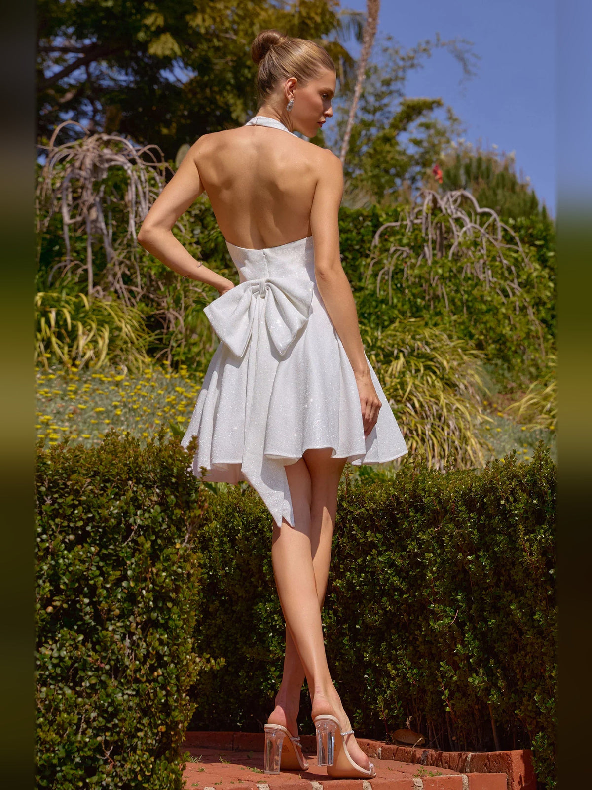 Sparkly white backless A-line mini dress with V-neck and draped waist bow