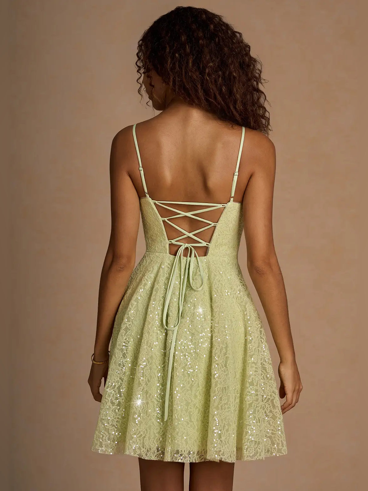 Back view of sage green sequin mini A-line dress with crisscross lace-up straps