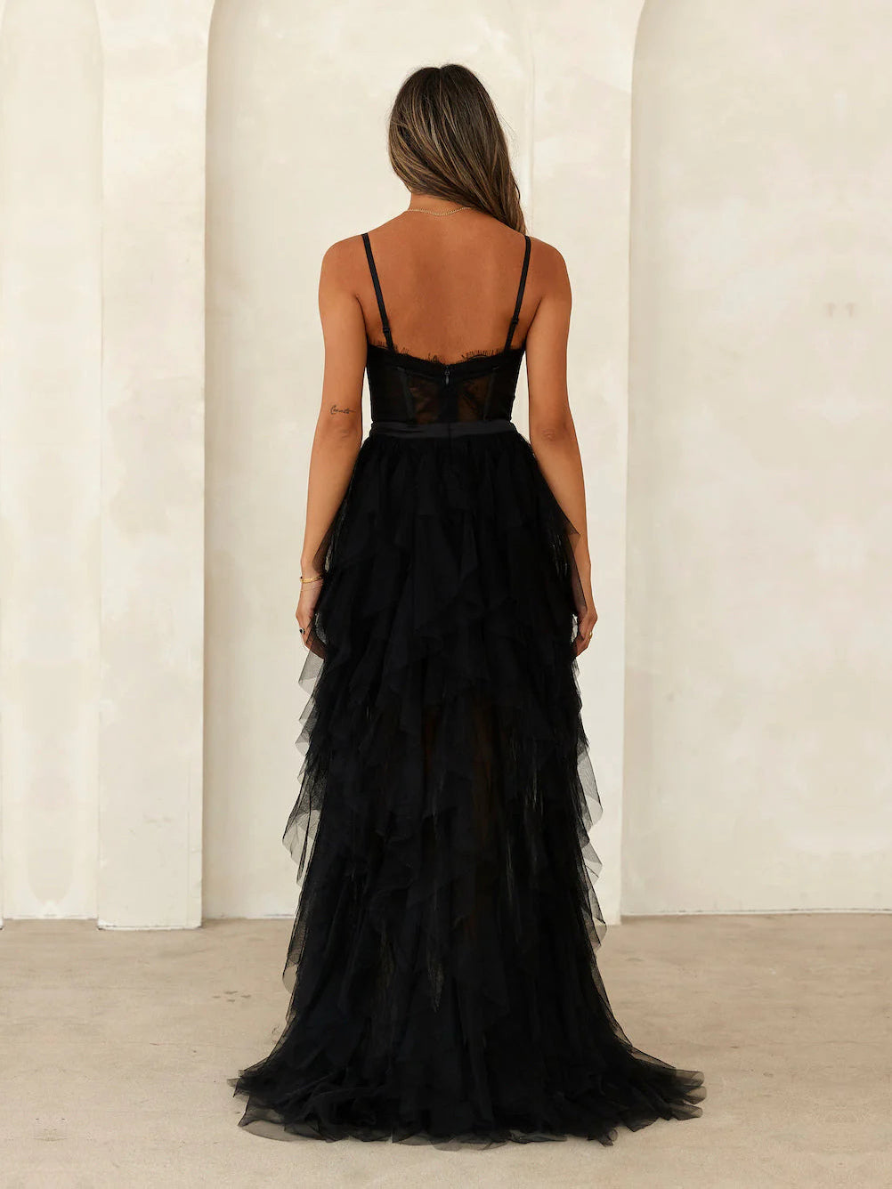 Black a-line maxi formal dress with ruffle details, full-length back view