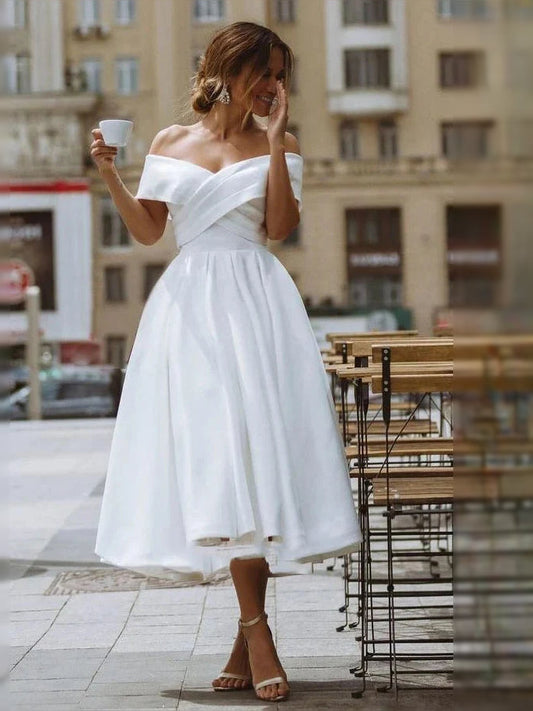 White off-shoulder A-line satin wedding dress with pleated skirt and fitted waist