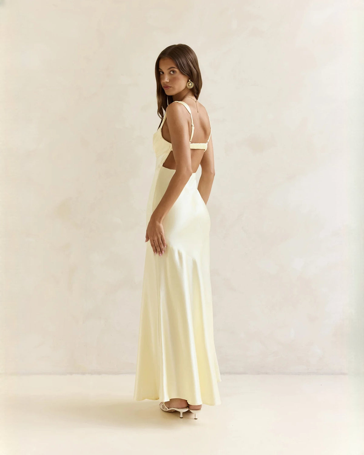 Sleeveless satin A-line maxi dress in pale yellow, side view with square neckline