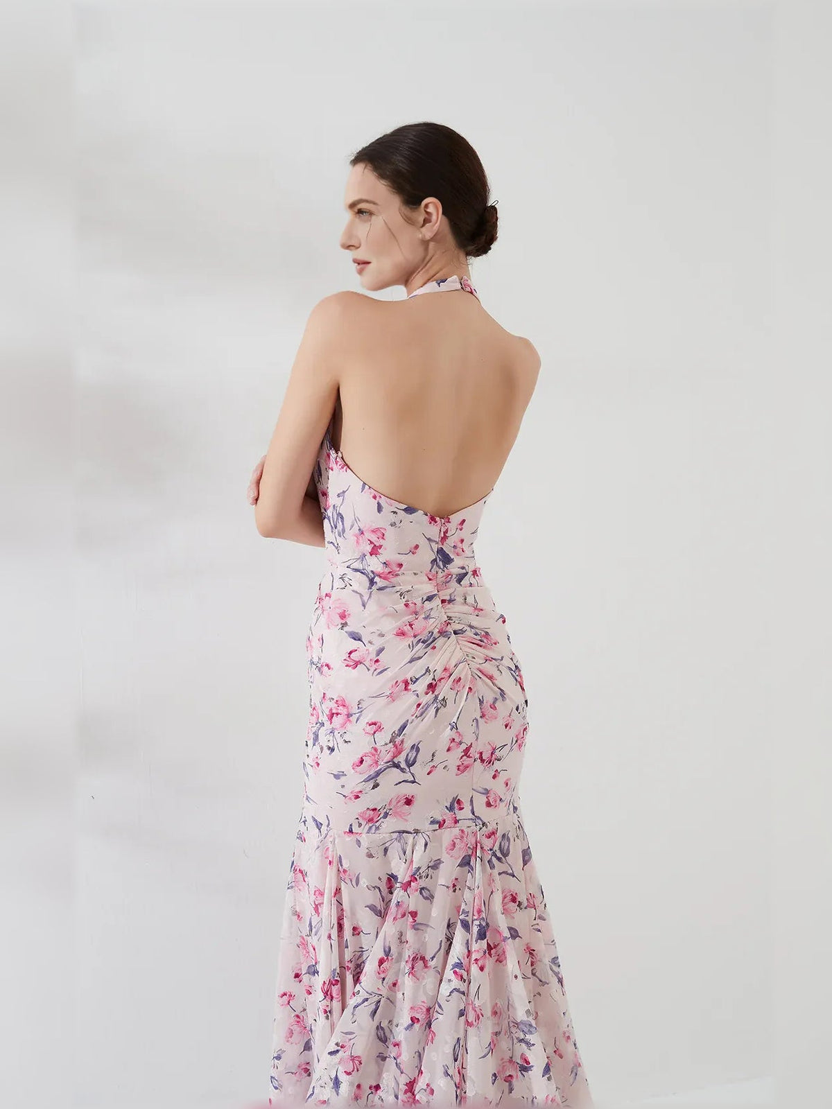 Floral open-back halter gown with ruched bodice and tiered floor skirt