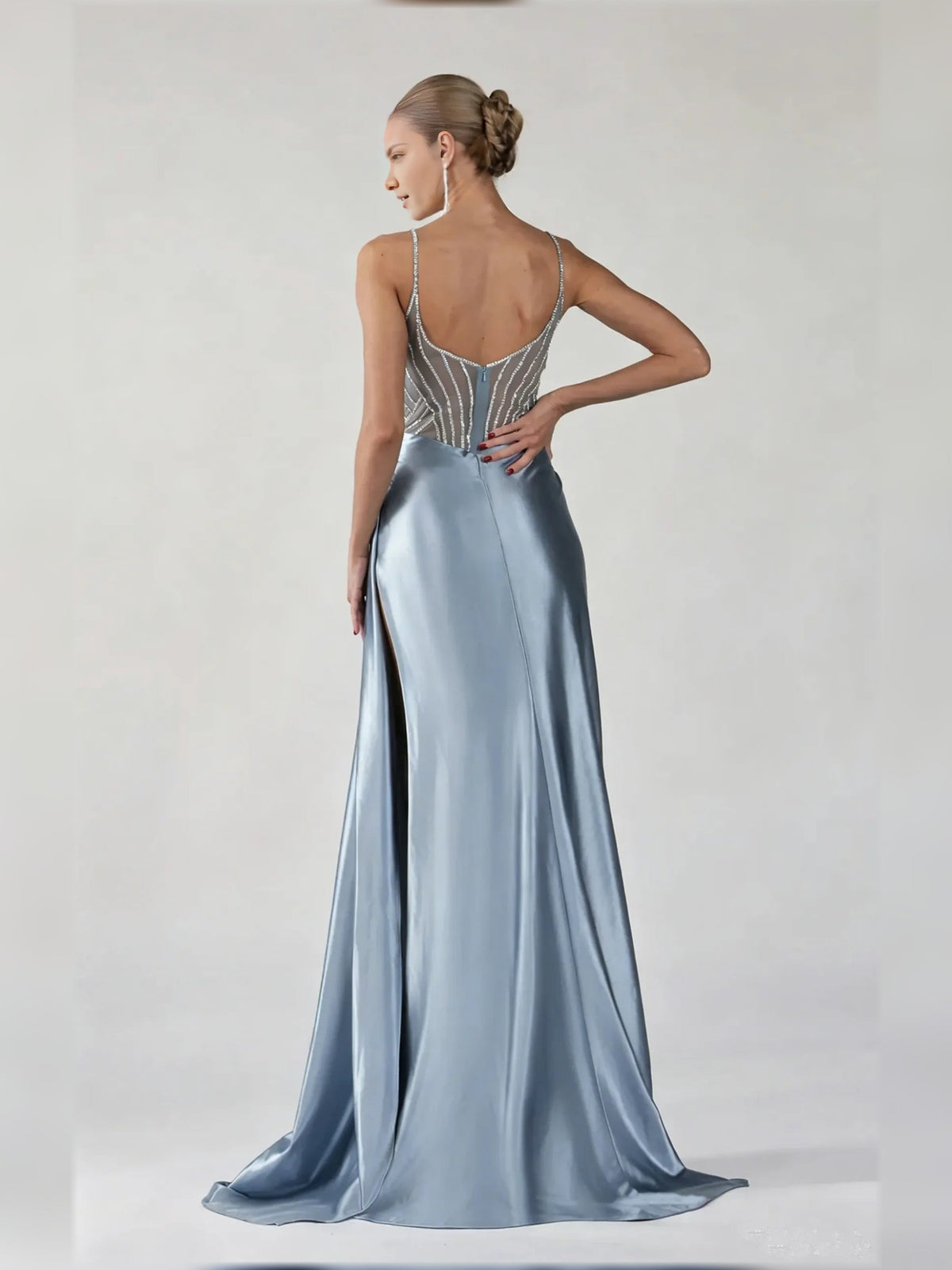 Powder blue satin formal dress from back view, spaghetti straps and flowing slit skirt