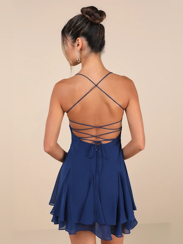 Dark blue backless mini dress with crisscross strap detailing and pleated tiers
