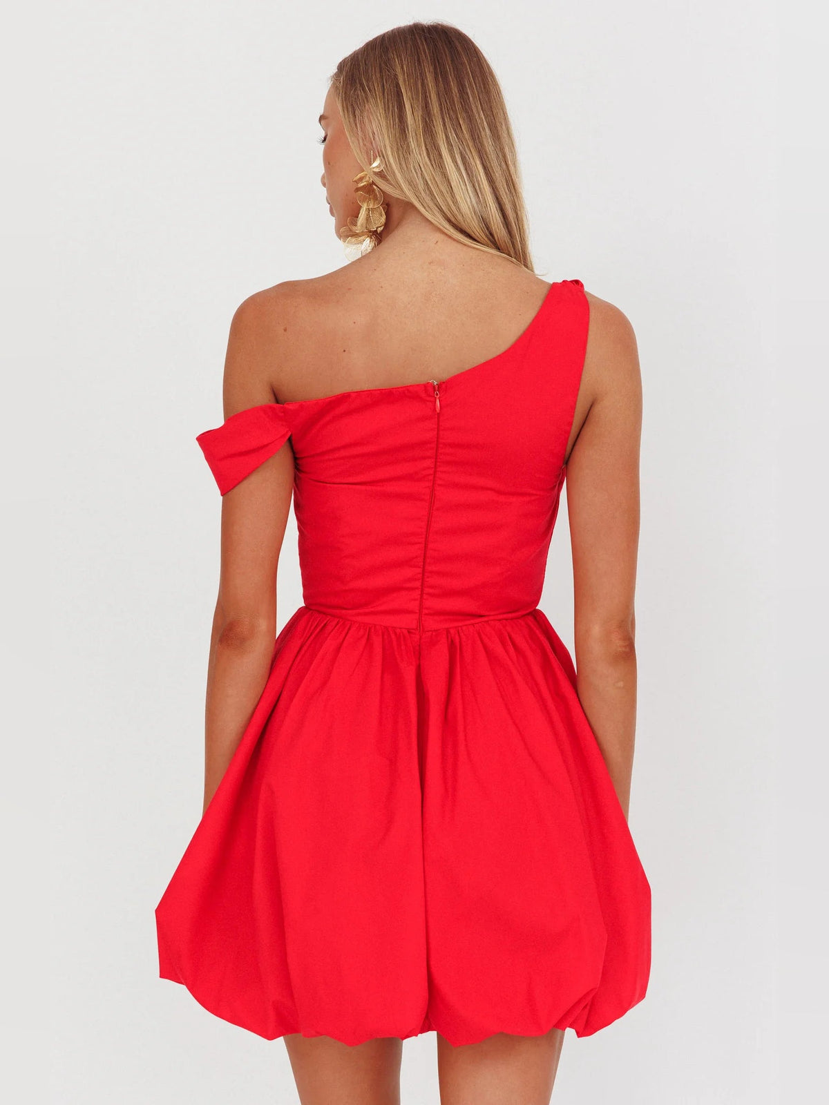 Back view of red asymmetrical mini homecoming dress with corset-style seams and flared skirt