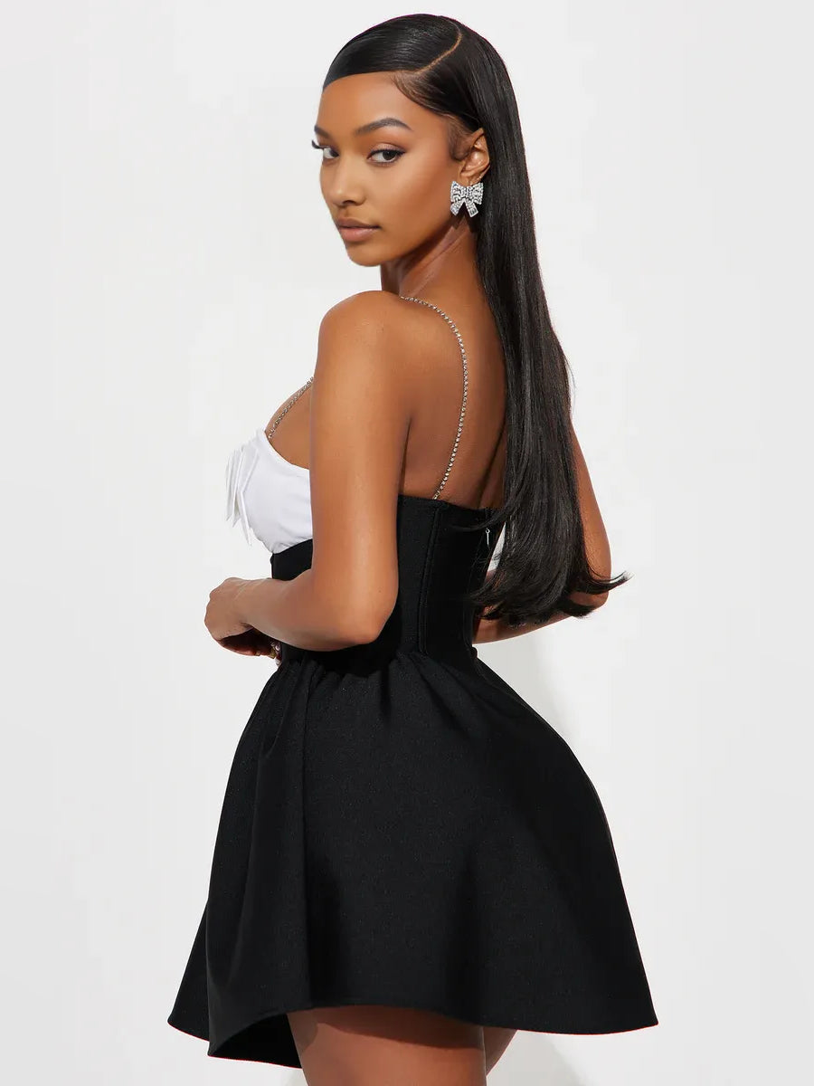 Sweetheart corset mini dress with white spaghetti straps and black flared skirt, back view