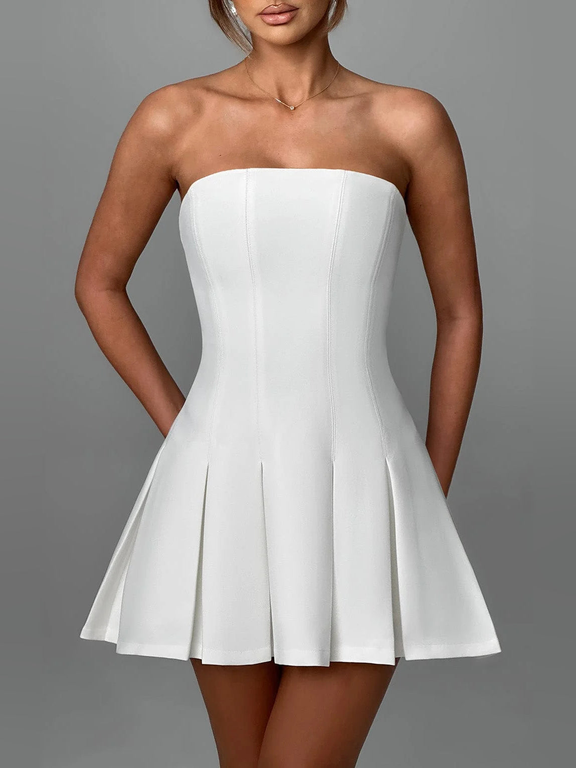 Ivory strapless mini dress with smooth corset-style bodice and pleated swing skirt