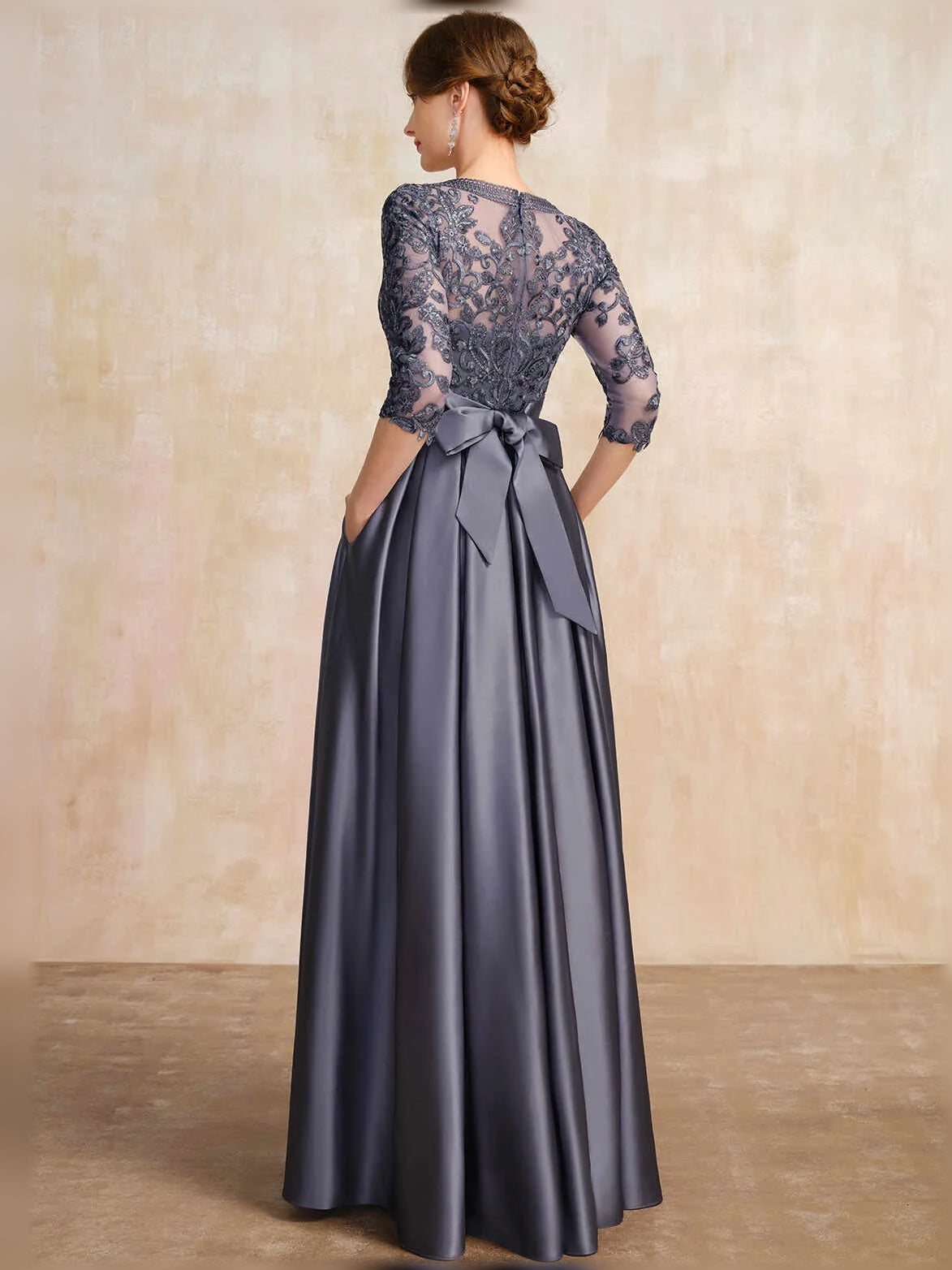 Dark blue satin A-line dress from back, lace sleeves, bow at waist, pleated skirt