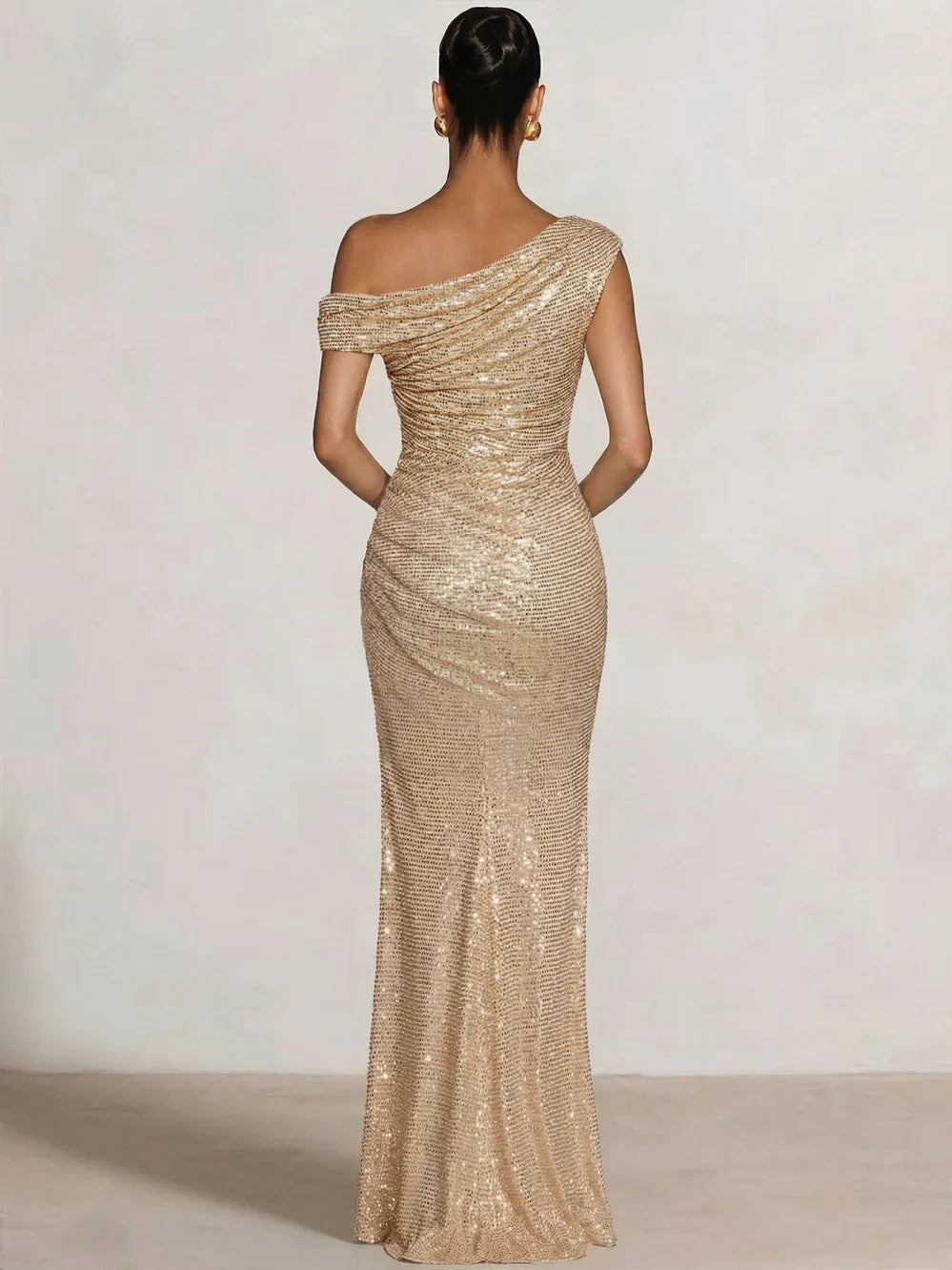 Champagne one-shoulder sequin mermaid gown, draped back detail, floor length.
