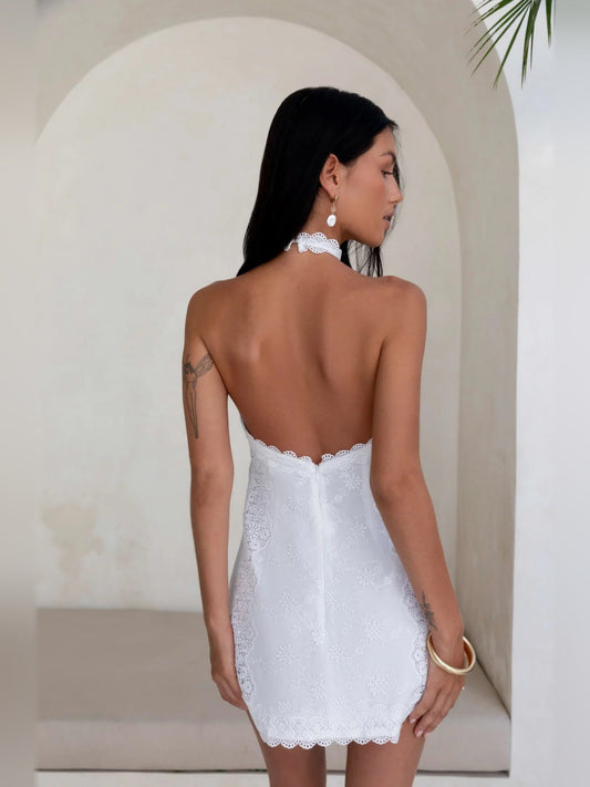 White halter mini dress shown from back, lace fabric and scalloped hem edges