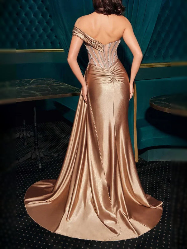 Champagne one-shoulder corset dress, back view, silver beading and flowing slit skirt