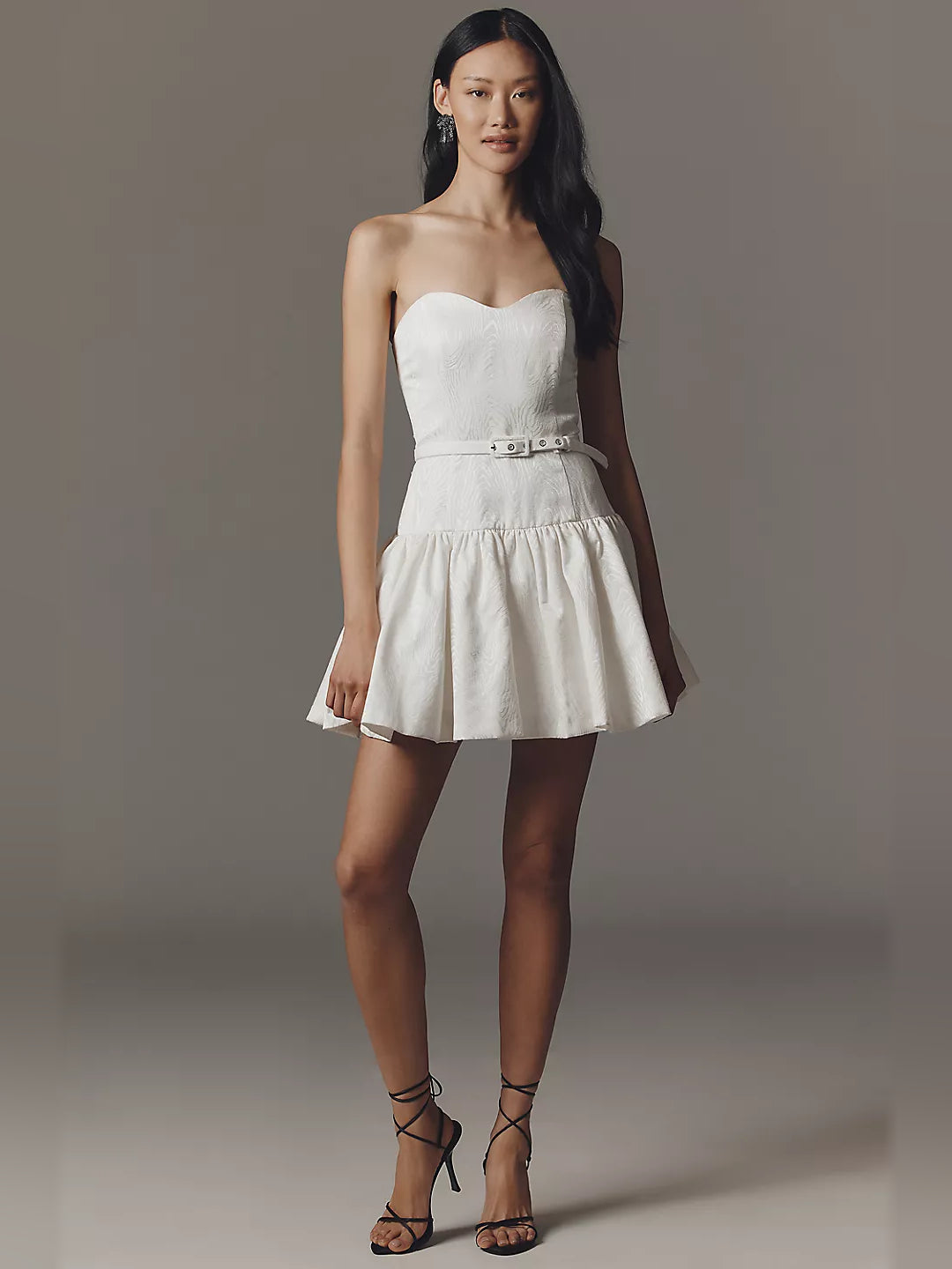 White strapless mini homecoming dress with corset-style belt and flared tiered skirt