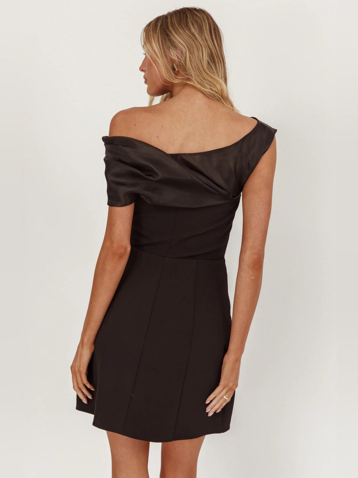 Black off-shoulder mini dress, back view with draped neckline detail