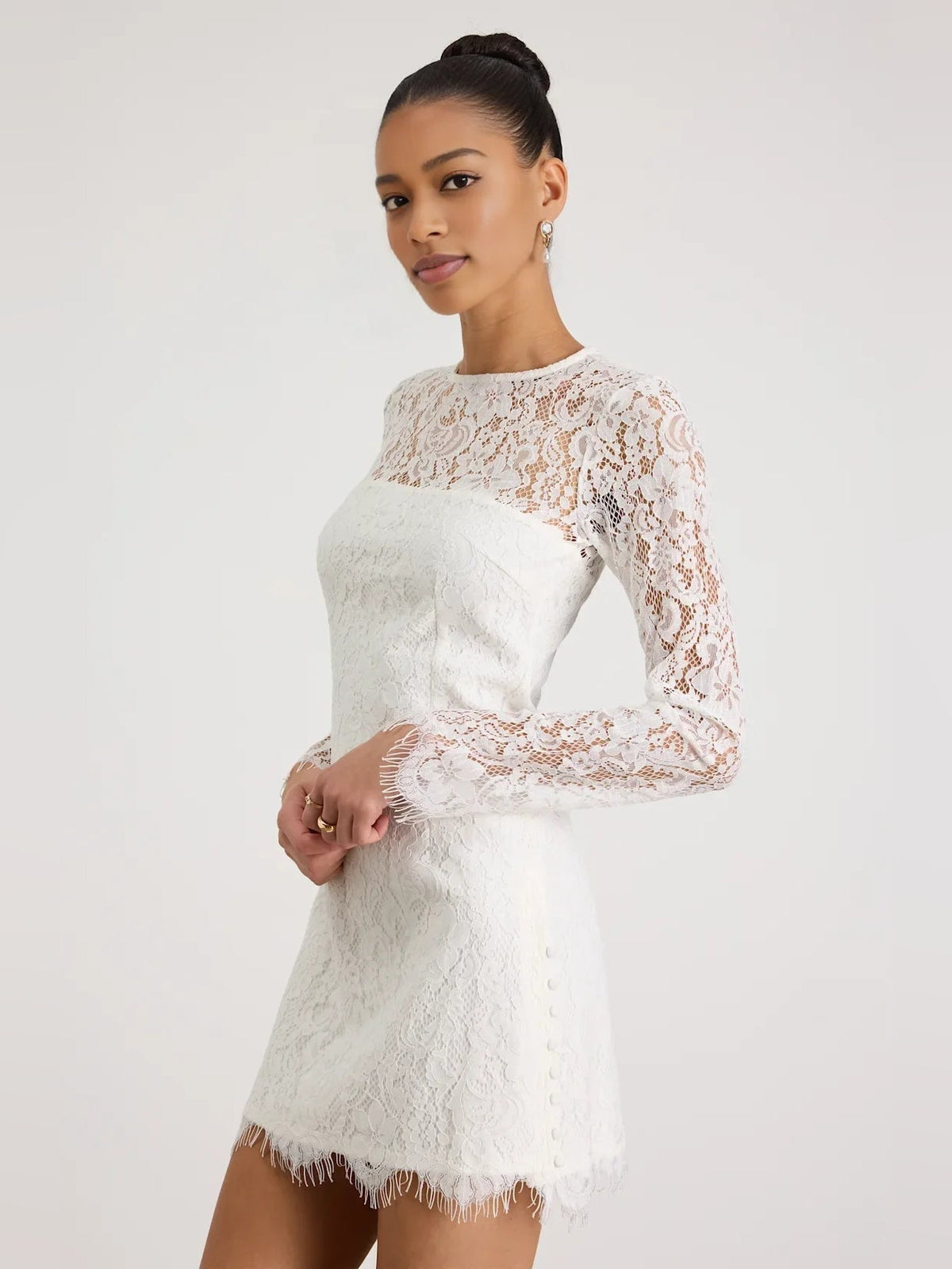 White lace long-sleeve mini dress with fitted sheath silhouette and floral back detail