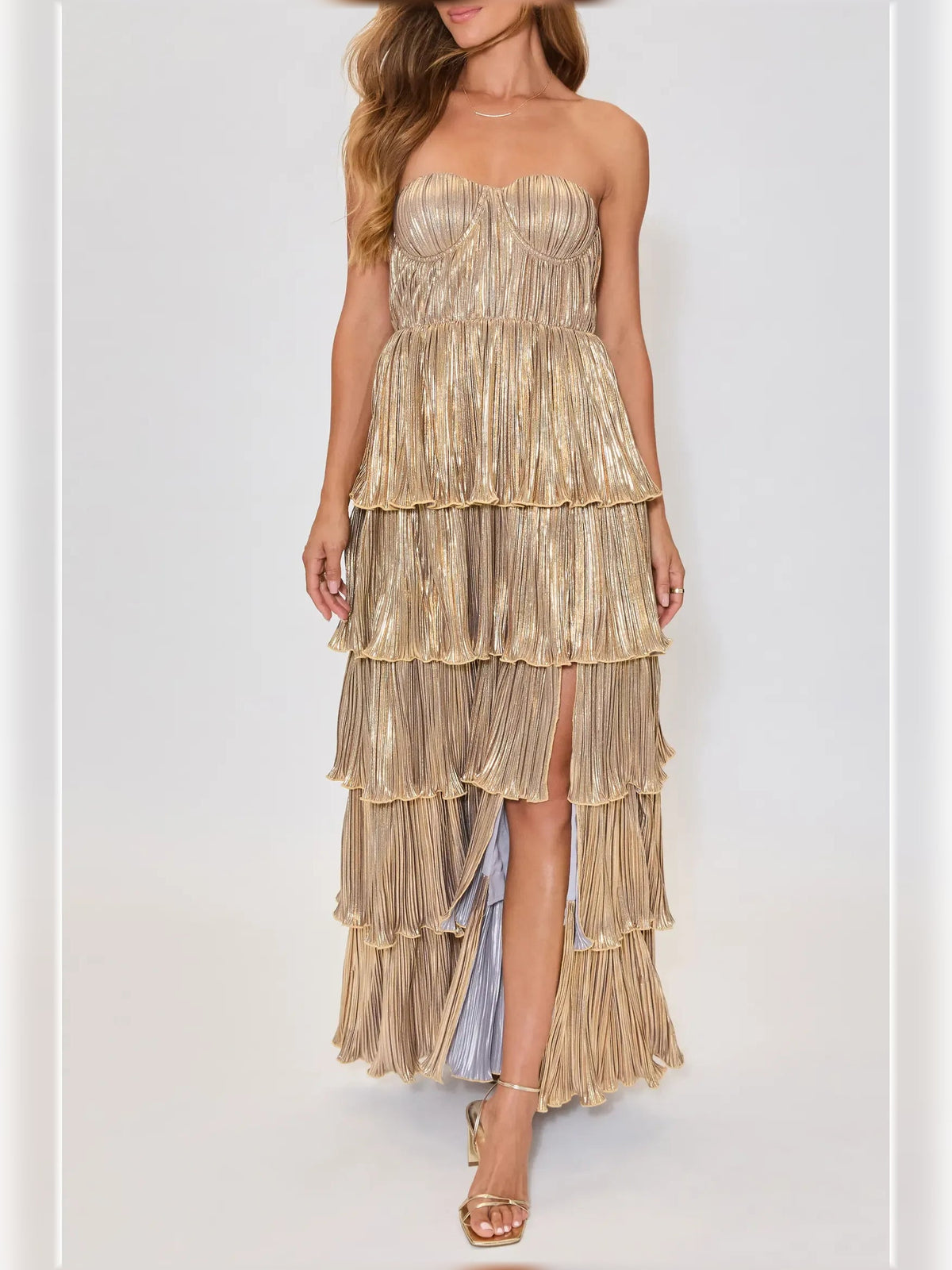 Gold strapless tiered formal dress with vertical pleats and ruffle hems