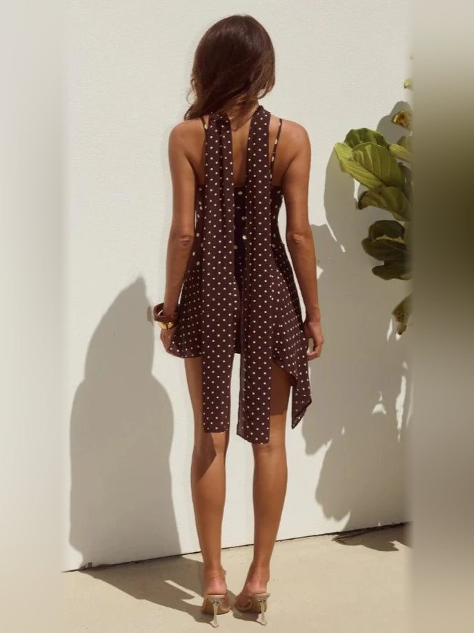 Back view of brown polka-dot mini homecoming dress with draped hem and spaghetti straps