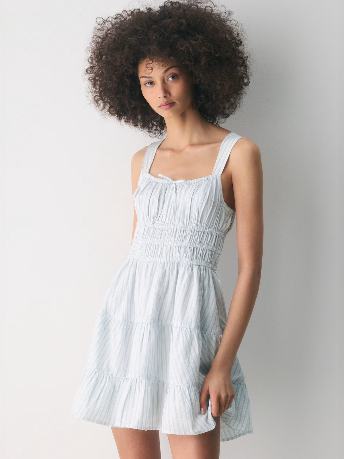 Light blue tiered mini dress with thin straps and gathered bodice