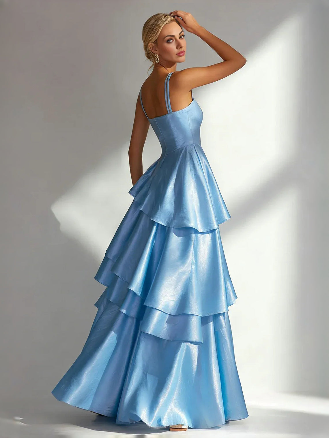 Light blue satin A-line prom dress with square neckline and layered ruffle skirt, thin straps.
