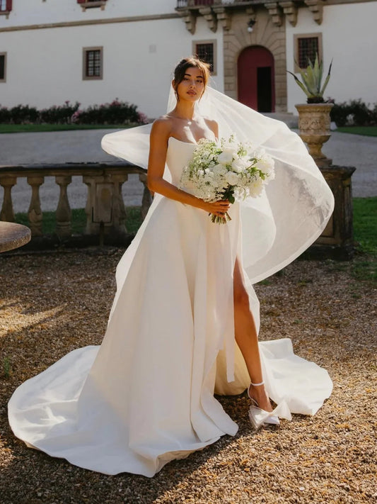 White satin sweetheart A-line wedding dress with veil and draped side slit