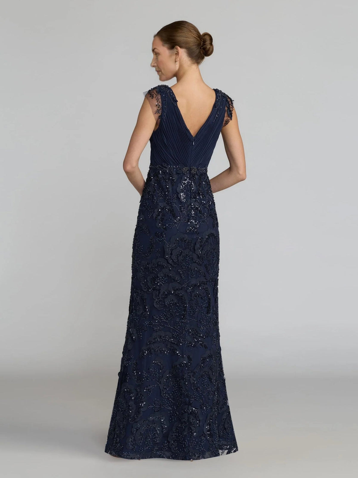 Dark blue floor-length sleeveless V-neck gown with draped waist and beadwork