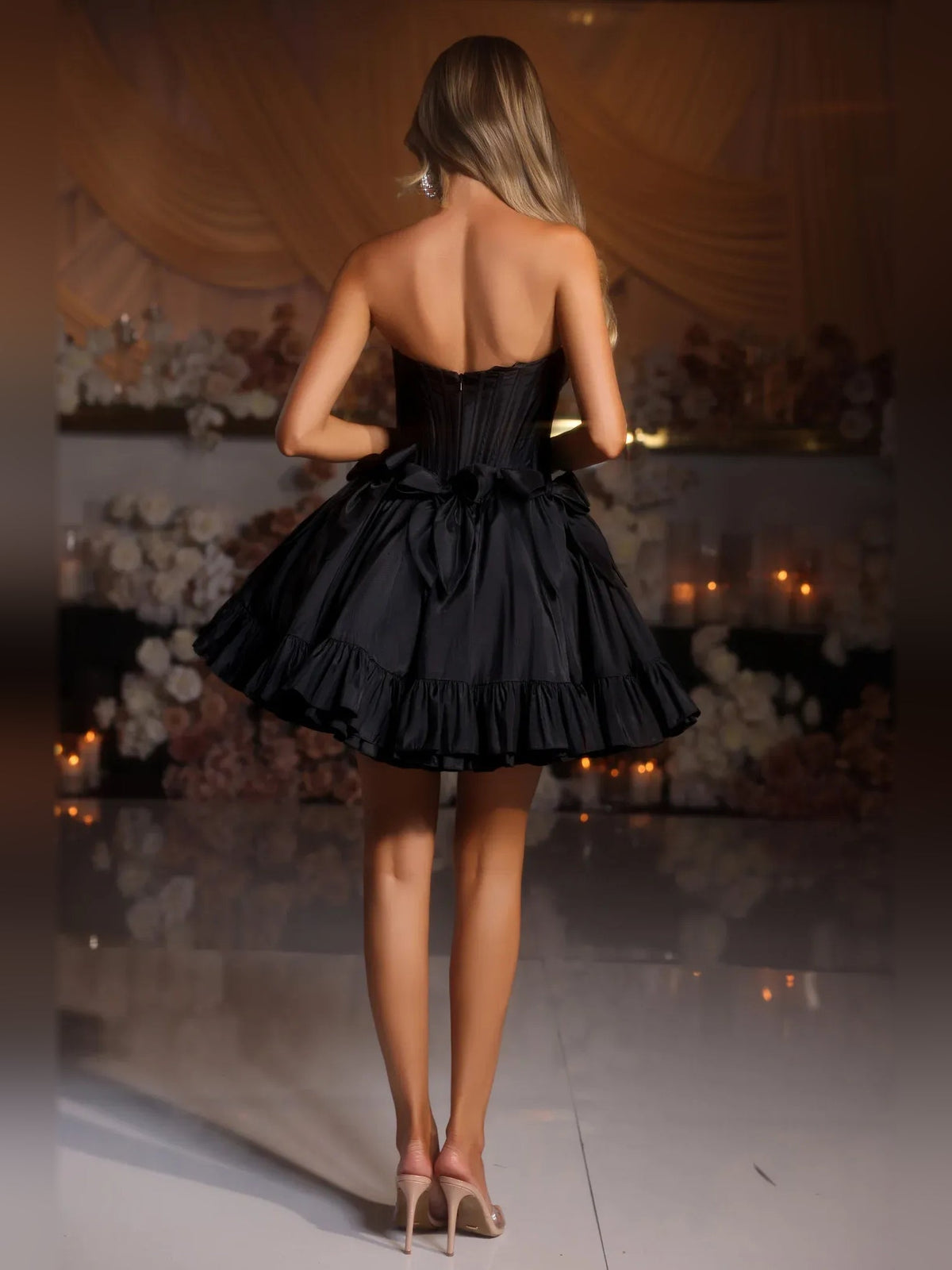 Black strapless satin corset mini dress, back view, with ruffled tier skirt
