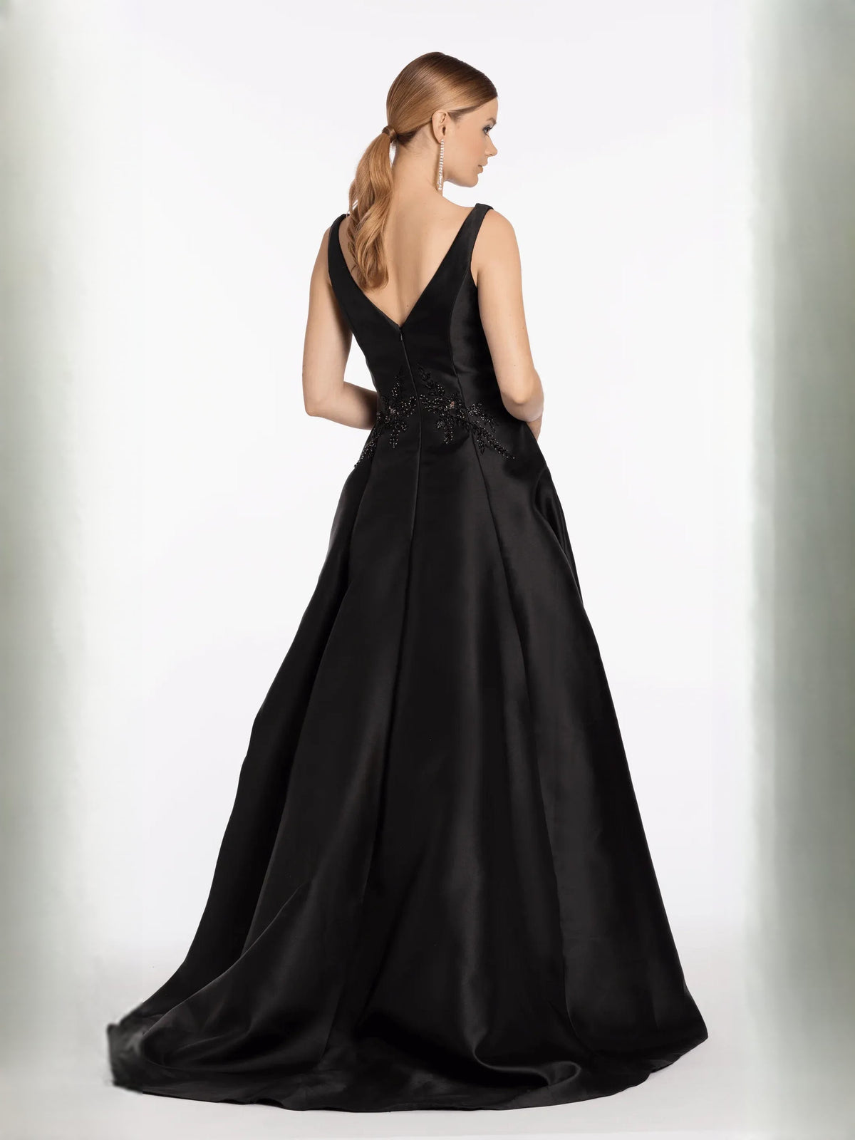 Black V-neck sleeveless formal dress with beaded waist detail and full A-line skirt