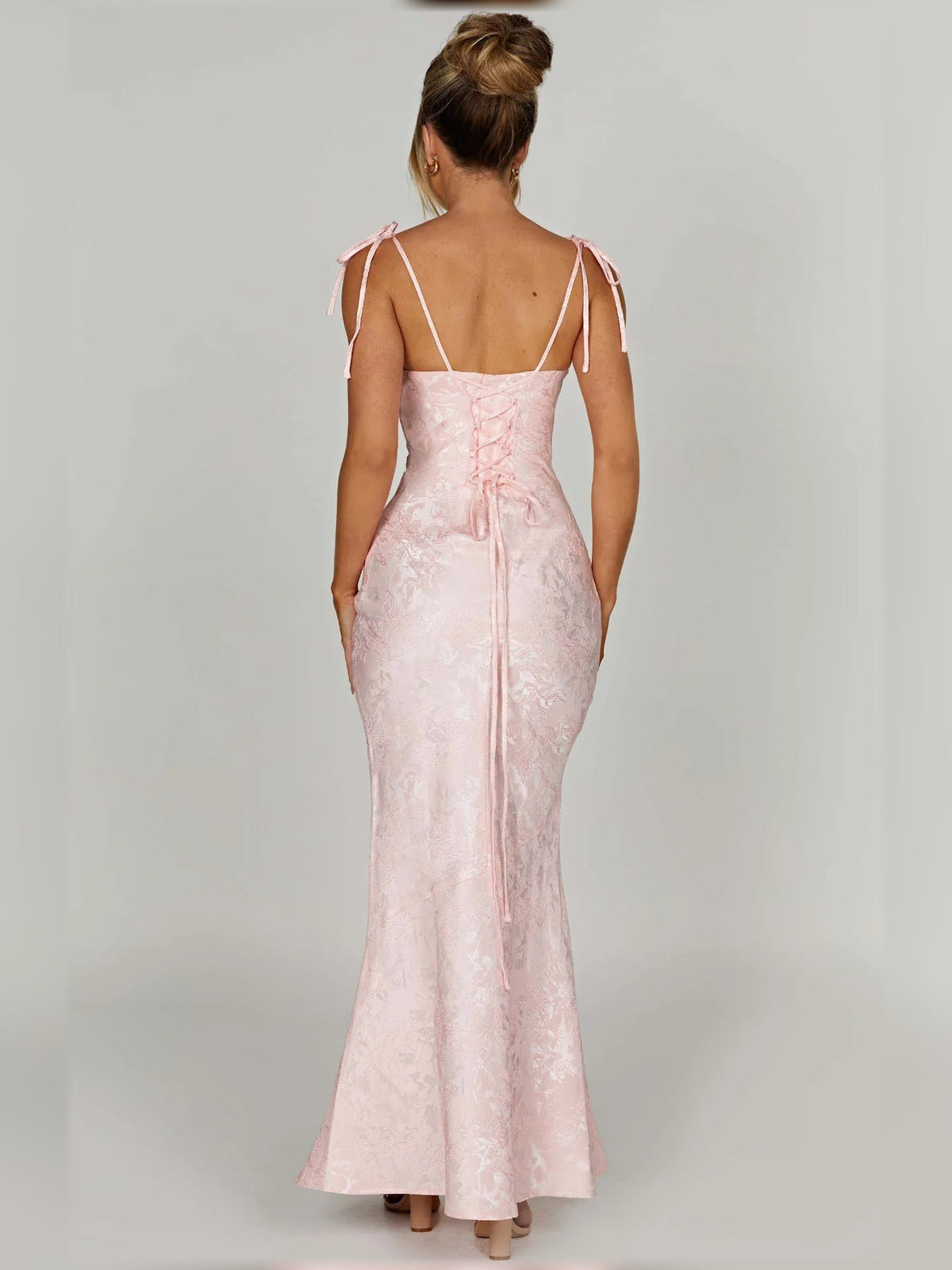 Blush pink floral formal dress from back view with lace-up detailing, spaghetti straps, maxi length
