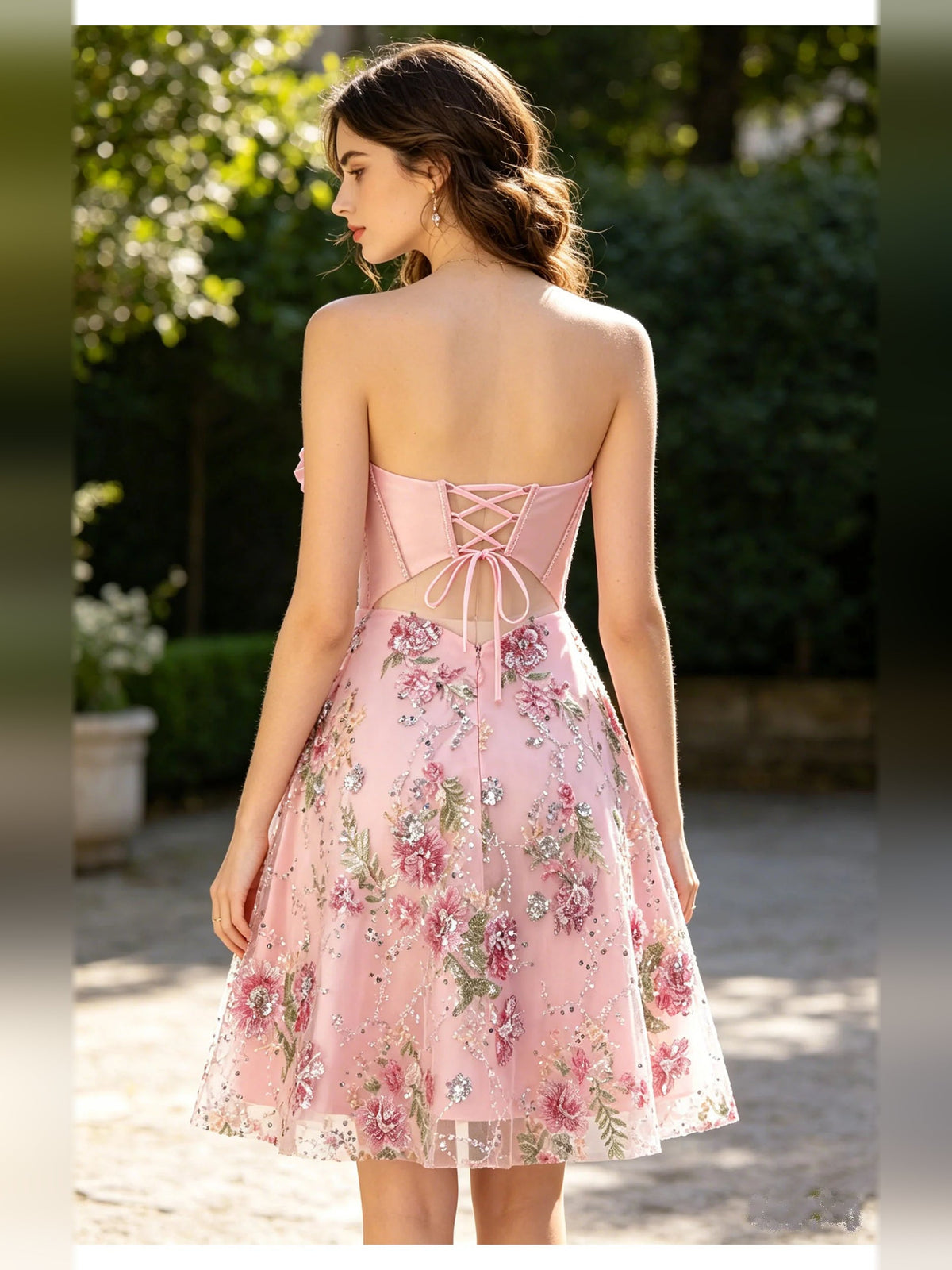 Back view light pink strapless corset dress with crisscross laced back and floral skirt