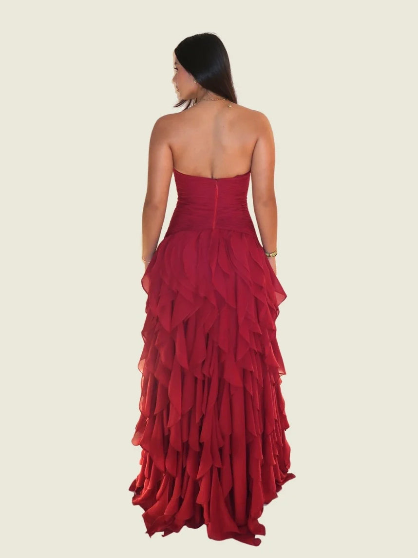 Back view of a red strapless sweetheart ball gown with ruched bodice and layered ruffles