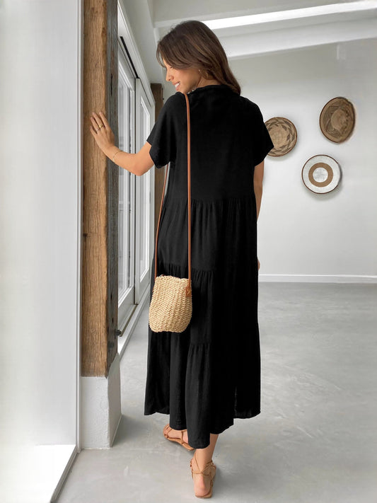 Black midi dress from back view with short sleeves and tiered, buttoned bodice