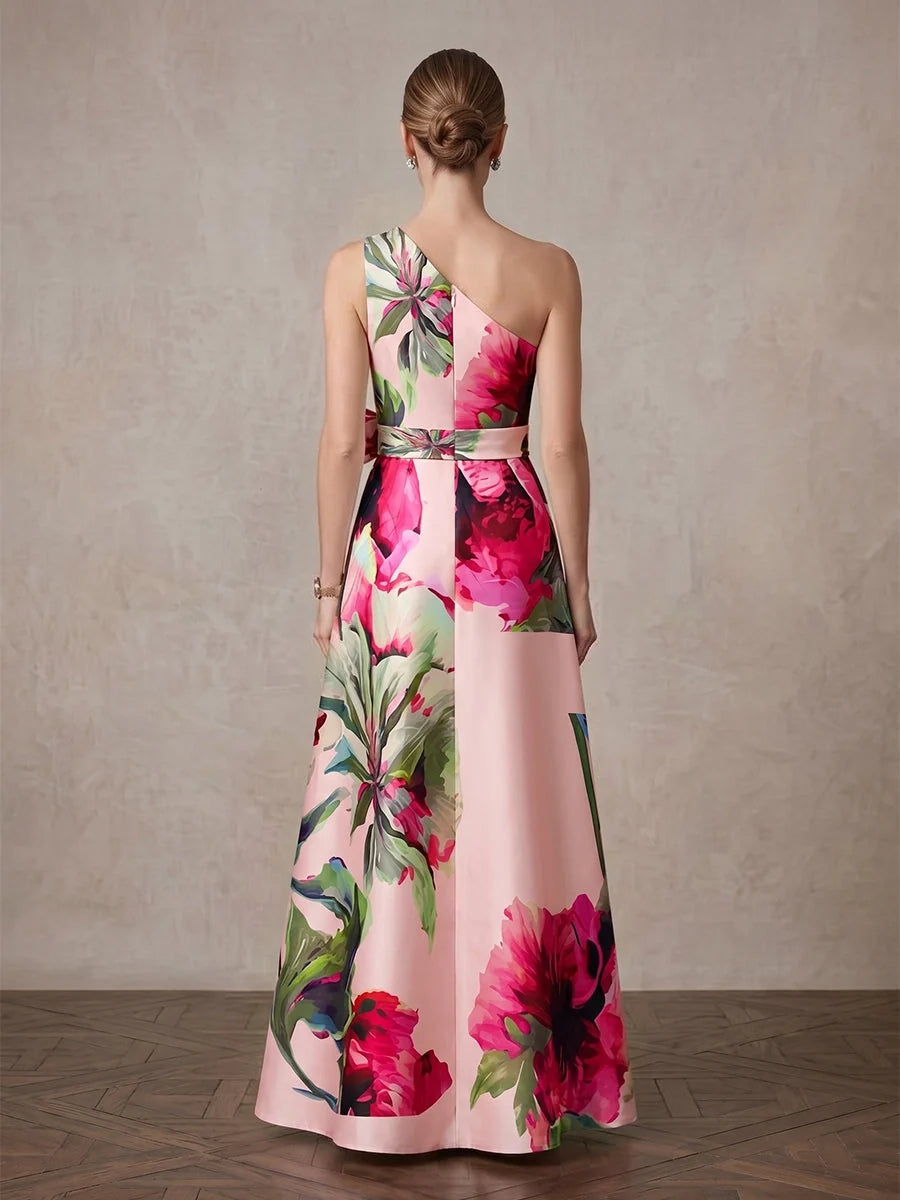 Back view of light pink floral one-shoulder A-line satin gown, floor-length.