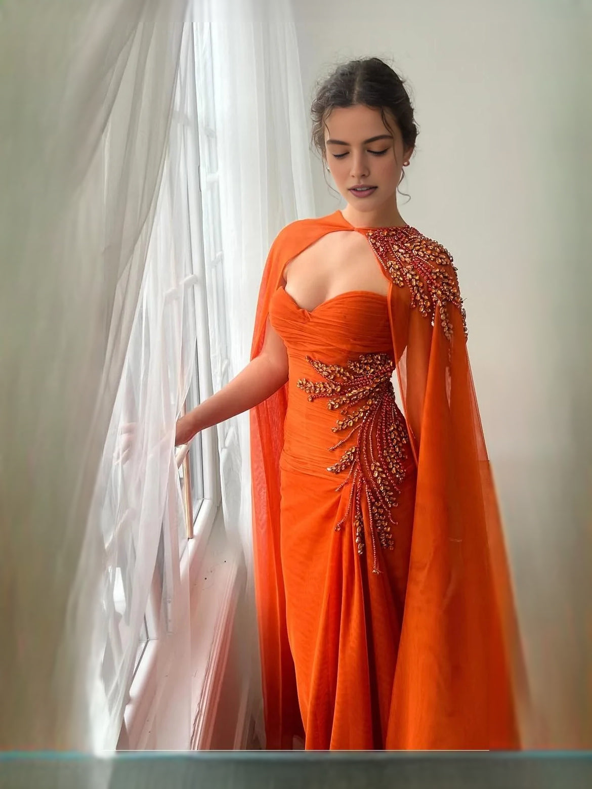 Burnt orange strapless sweetheart mermaid prom dress with ruched bodice and beadwork