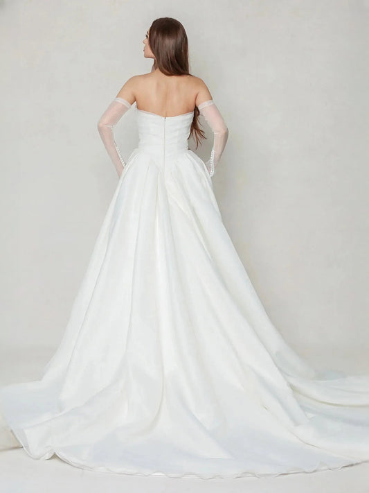 Ivory strapless wedding dress from back view with pleated full skirt and long train