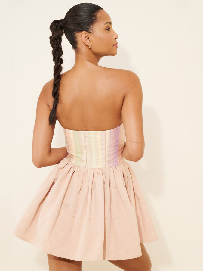 Back view of light pink mini strapless dress with gathered waist and flared skirt