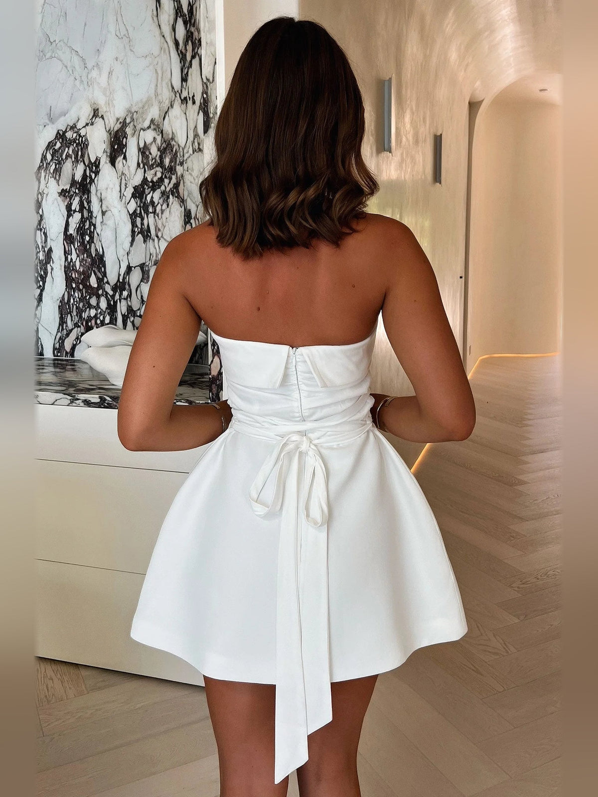 Back view ivory white strapless A-line mini dress with gathered waist tie