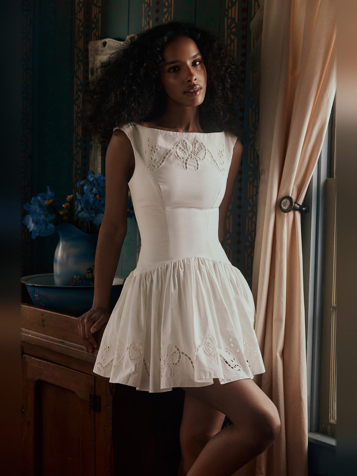 White sleeveless boat-neck mini dress with embroidered eyelet detail on bodice and hem