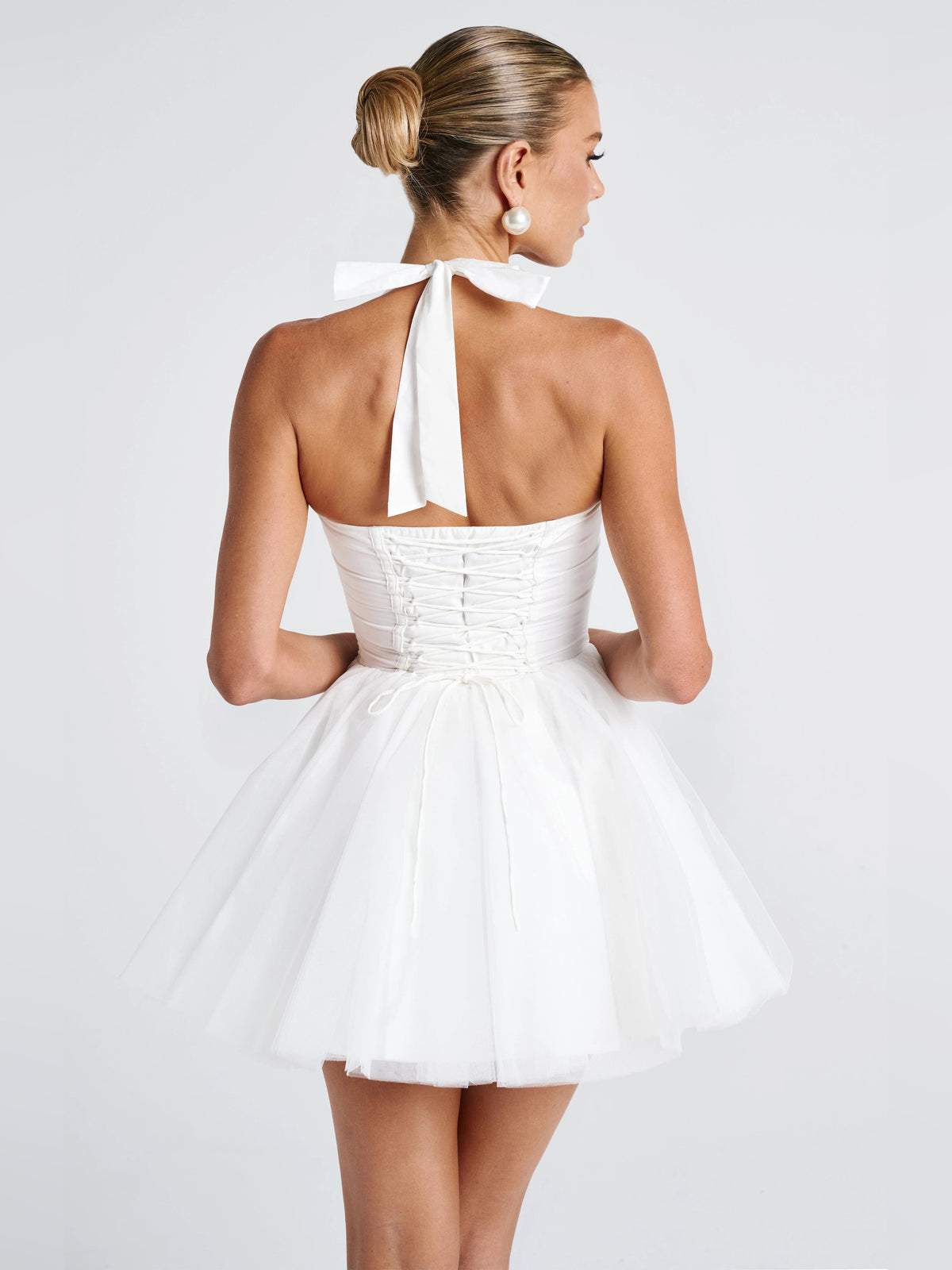 Ivory mini dress from back view with halter tie and layered tulle skirt