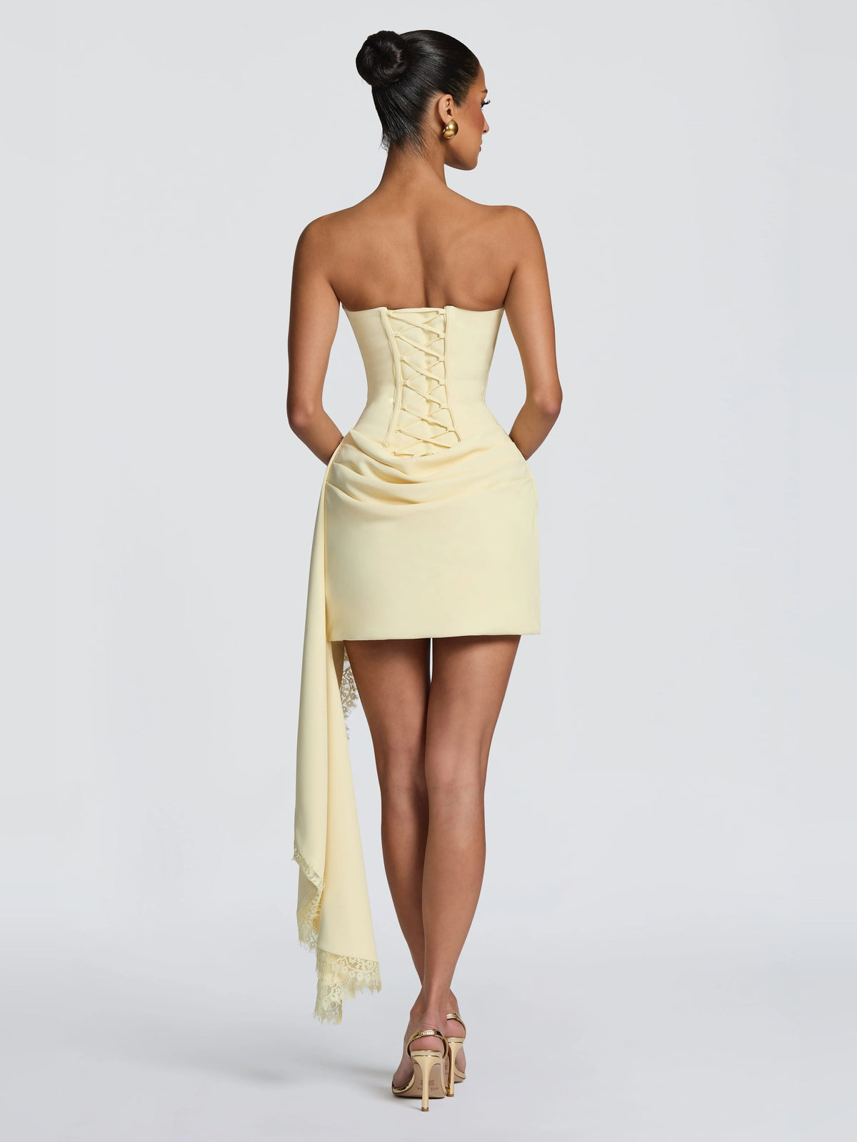 Lemon mini dress back view with corset boning and lace-trimmed drape sash