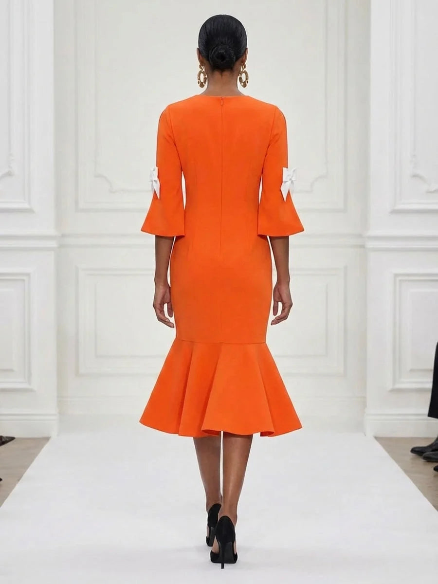 Back view of burnt orange mermaid midi dress with bow-detail sleeves and ruffled skirt hem
