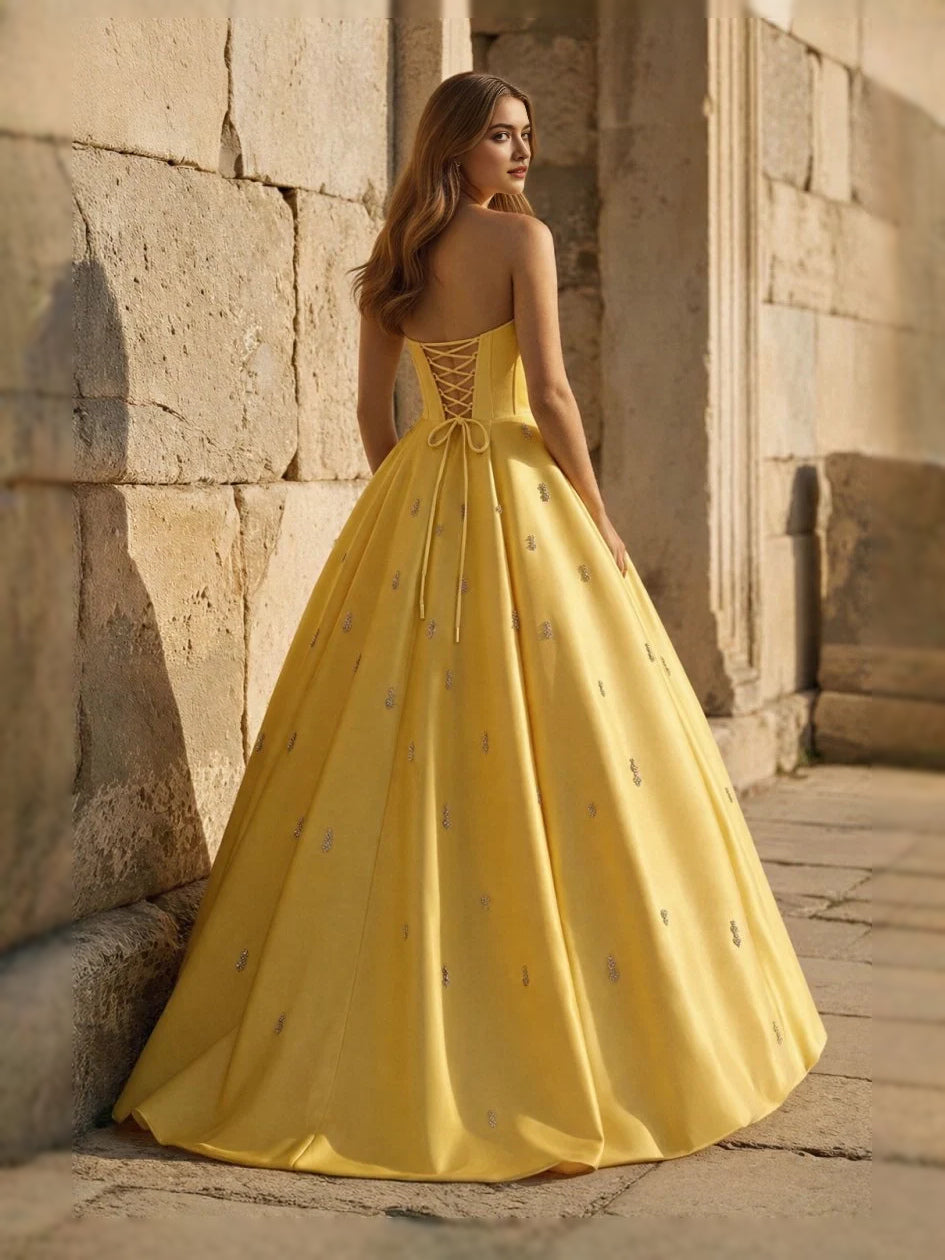 Yellow sweetheart corset ball gown with thin straps and full floor-length skirt, side view