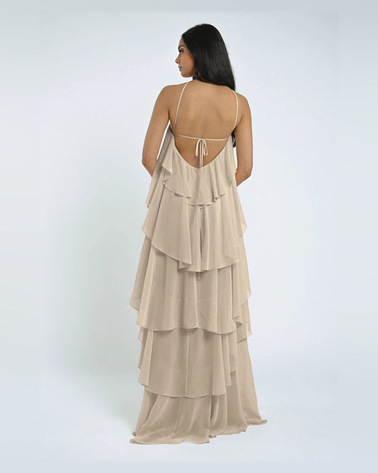 Back view of off-white A-line maxi dress with open halter straps and tiered ruffles.